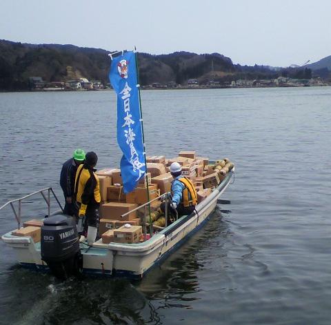 3月25日、気仙沼港から大島に向け 出港する小型船に乗り込む津田副支部長 